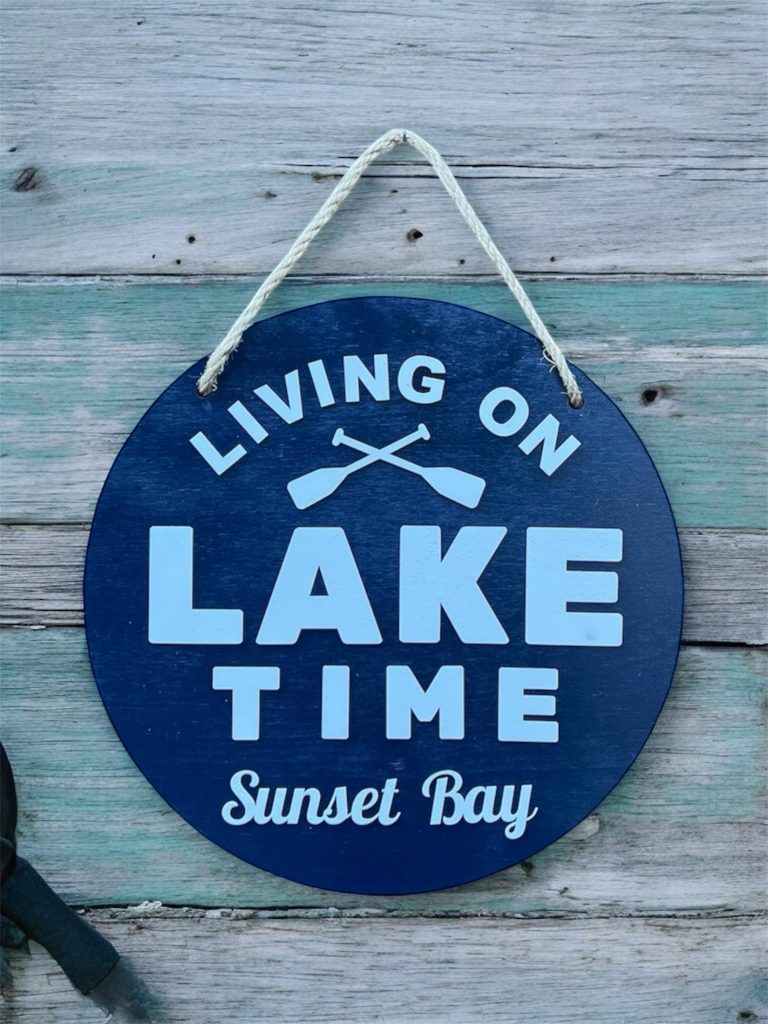 14" round sign, hung by rope hanger, navy blue background with white text.